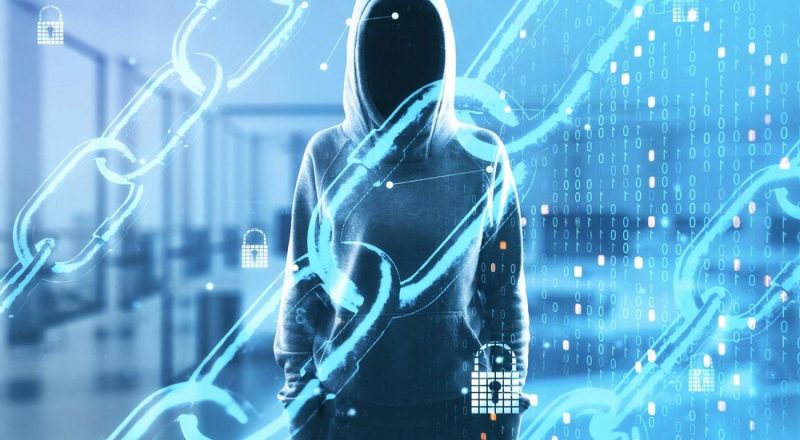 Hooded figure behind chains and binary code representing cybersecurity threats facing UAE businesses